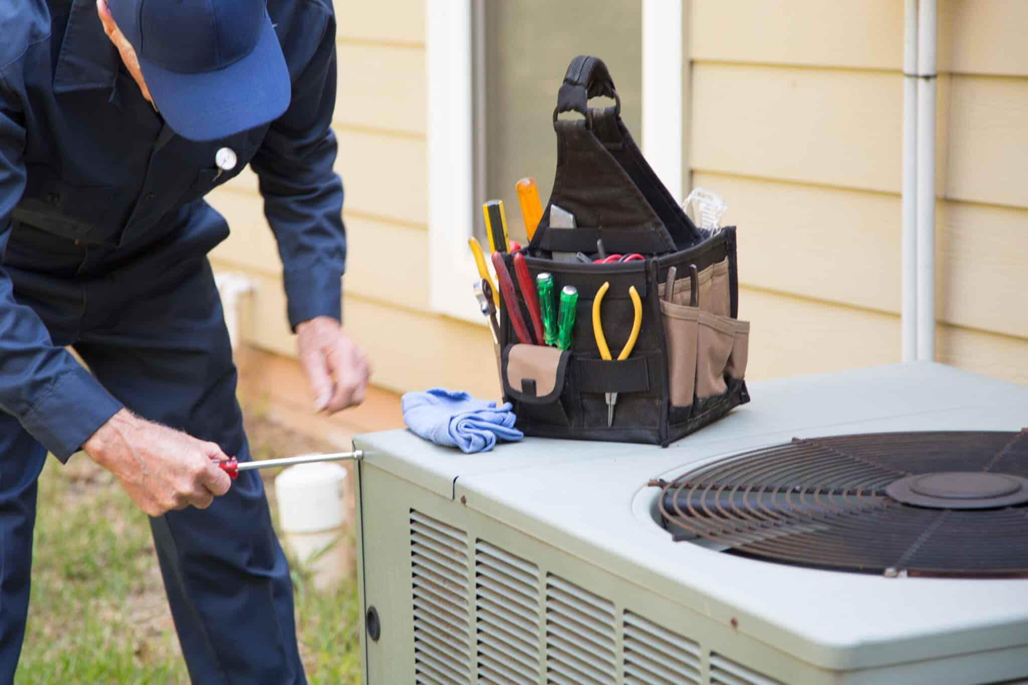 HVAC technician servicing an outdoor air conditioning unit